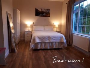 - une chambre avec un lit, 2 tables de nuit et 2 lampes dans l'établissement Family Home, 20 mins from Youghal Beach, à Killeagh