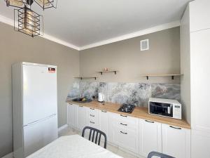 a kitchen with white cabinets and a white microwave at # 22 Яркая и уютная квартира MODERN in Atyrau