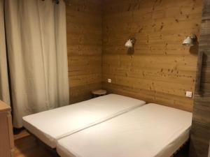 two beds in a room with wooden walls at Appartement 2 chambres centre MORZINE in Morzine