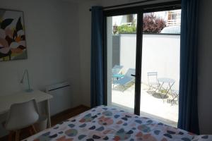 Schlafzimmer mit einem Bett und einer Glasschiebetür in der Unterkunft Maison 8 pers 1 minute parc des expositions in Bohars