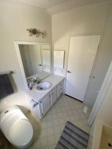 Baño blanco con lavabo y espejo en Wine Country House (4 people), en Villa de Juárez