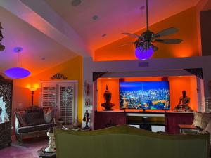 un soggiorno con ventilatore a soffitto e TV a schermo piatto di Z House a Las Vegas