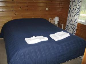 Una cama azul con toallas blancas encima. en Koli Country Club, en Hattusaari