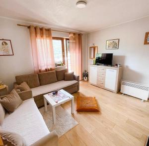 a living room with a couch and a table at Slatki dom Fireplace in Konjic