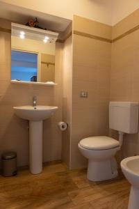W łazience znajduje się umywalka, toaleta i lustro. w obiekcie La Stazione w mieście Trontano