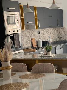 奧蘭的住宿－Luxueux T3 à Oran.，厨房配有桌椅和微波炉。