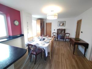 a dining room with a white table and chairs at Lyndale House - North Norwich suburbs - Hot Tub April to October in Norwich
