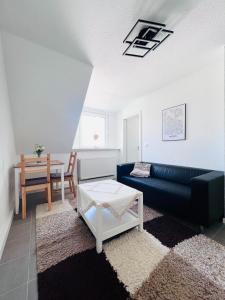 een woonkamer met een blauwe bank en een tafel bij Voll ausgestattet und gemütlich in Wuppertal