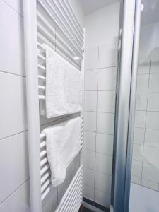 een badkamer met witte handdoeken op een handdoekenrek bij Voll ausgestattet und gemütlich in Wuppertal