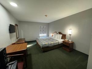 una habitación de hotel con una cama y un escritorio en Star City Inn & Suites, en Star City