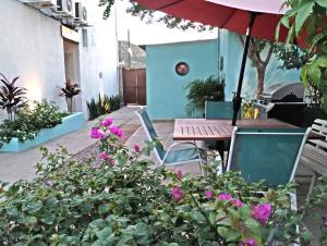 Un patio con una sombrilla y una mesa y sillas. en Tres Migueles, estudio Anna, cerca de la marina, zona turistica y playa, en Cabo San Lucas 9 fotos más