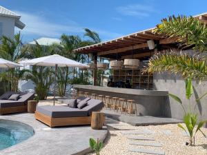 a patio with a bar and chairs and a pool at Livengood Properties BZ+The PoolClub@Mahogany Bay! in San Pedro
