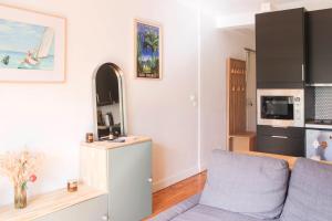 a living room with a couch and a kitchen at Crossing cocoon with balcony and clear view in Paris