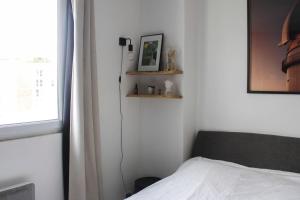 a bedroom with a bed and a window at Crossing cocoon with balcony and clear view in Paris