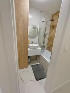 a white bathroom with a sink and a mirror at Apartmán v meste Michalovce in Michalovce