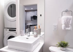 a white bathroom with a sink and a washing machine at Hemlock Hangout by Revelstoke Vacations in Revelstoke +33 photos