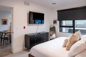 a bedroom with a bed and a tv on the wall at Hemlock Hangout by Revelstoke Vacations in Revelstoke