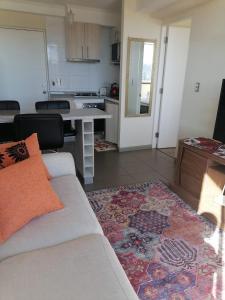 ein Wohnzimmer mit einem Sofa und einer Küche in der Unterkunft Departamento Mirador Camilo Henriquez in Concepción