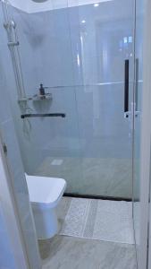 a bathroom with a toilet and a glass shower at Cozy 2 bedroom apartment With gym &washer near yaya centre in Nairobi