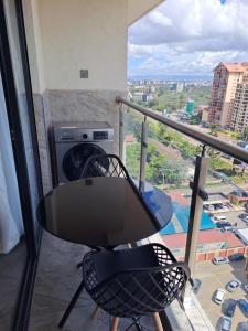 a table and a chair in a room with a window at Cozy 2 bedroom apartment With gym &washer near yaya centre in Nairobi