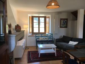 a living room with a couch and a table at Maison confortable et calme, 2 chambres in Saint-Marcel-Bel-Accueil