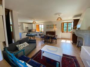 a living room with a couch and a table at Maison confortable et calme, 2 chambres in Saint-Marcel-Bel-Accueil