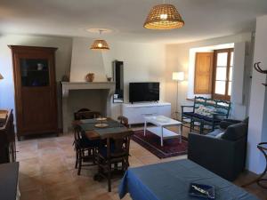 a living room with a couch and a table and a tv at Maison confortable et calme, 2 chambres in Saint-Marcel-Bel-Accueil +13 photos
