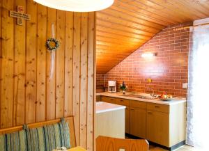 a kitchen with a wooden wall and a sink at Ferienhaus Endl in Freyung