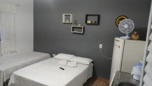 a small room with a bed and a refrigerator at Hospedagem Santo Agostinho in Extrema