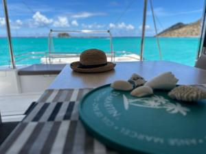 a hat sitting on a table in front of a boat at Room in Boat - Unusual night in catamaran with dinner in Grand Case