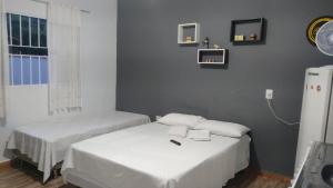 - une chambre avec 2 lits, une fenêtre et un réfrigérateur dans l'établissement Hospedagem Santo Agostinho, à Extrema