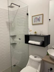 uma casa de banho com um WC e uma cabina de duche em vidro. em Deko rooms em Arauca