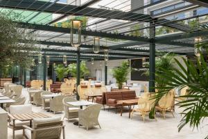a restaurant with tables and chairs and glass ceilings at EVOLUTION Cascais-Estoril Hotel in Estoril