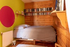 a bedroom with a bed and a book shelf at Large duplex house with terrace in Bordeaux in Bordeaux