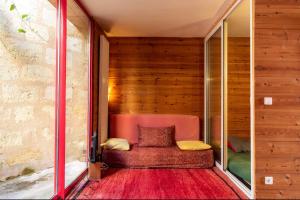 Habitación pequeña con una silla roja en una pared de madera. en Large duplex house with terrace in Bordeaux, en Burdeos