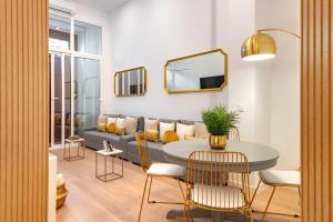 ein Wohnzimmer mit einem Sofa, einem Tisch und Stühlen in der Unterkunft Smart Apartment Near Puerta Del Sol in Madrid
