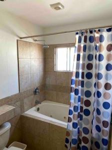een badkamer met een bad en een douchegordijn bij Casa para toda la familia in Ensenada