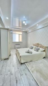 1 dormitorio con 1 cama grande en una habitación en # 268 Светлая и уютная квартира, en Atyraū