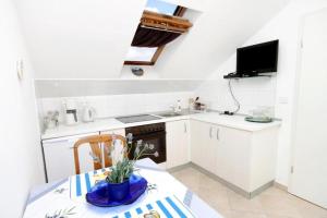 a kitchen with white cabinets and a table and a sink at Apartments Malo Misto in Zavalatica