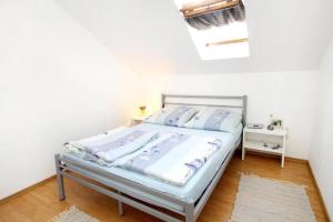 a bed in a bedroom with a white wall at Apartments Malo Misto in Zavalatica