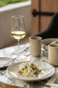 a plate of food on a table with a glass of wine at EVOLUTION Cascais-Estoril Hotel in Estoril