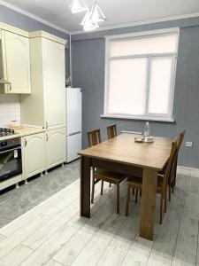 a kitchen with a table and chairs and a refrigerator at # 268 Светлая и уютная квартира in Atyraū