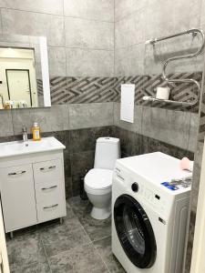 bagno con lavatrice e servizi igienici di # 268 Светлая и уютная квартира a Atyraū