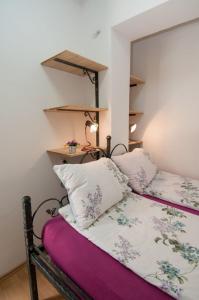 un letto con due cuscini sopra in una stanza di Apartments Lovran a Lovran (Laurana)