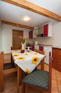 una cucina con tavolo e vaso di fiori di Apartments Lovran a Lovran (Laurana)