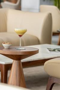 a glass of wine sitting on a wooden table at EVOLUTION Cascais-Estoril Hotel in Estoril