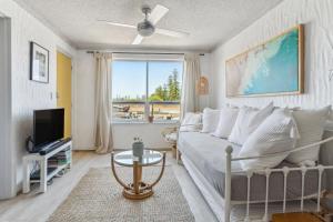 a living room with a couch and a tv at Gorgeous Gordon Street Getaway in Glenelg