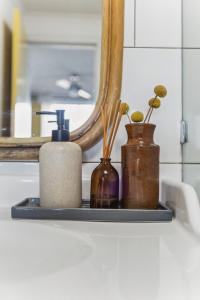 a bathroom shelf with three bottles and a mirror at Gorgeous Gordon Street Getaway in Glenelg +13 photos