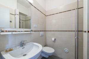 a bathroom with a sink and a toilet and a mirror at Hotel Elefant in Auer