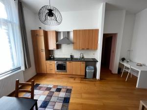 uma cozinha com armários de madeira e uma mesa num quarto em L&L apartment em Bruxelas